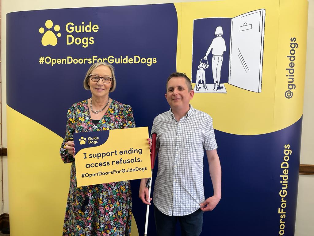 Gill Furniss MP holding a sign pledging to support ending access refusals, standing next to a representative from Guide Dogs.